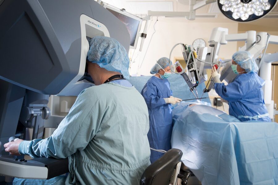 Cirurgia robótica: os instrumentos introduzidos no corpo do paciente são conectados aos braços do robô. O cirurgião sentado no console controla estes braços.